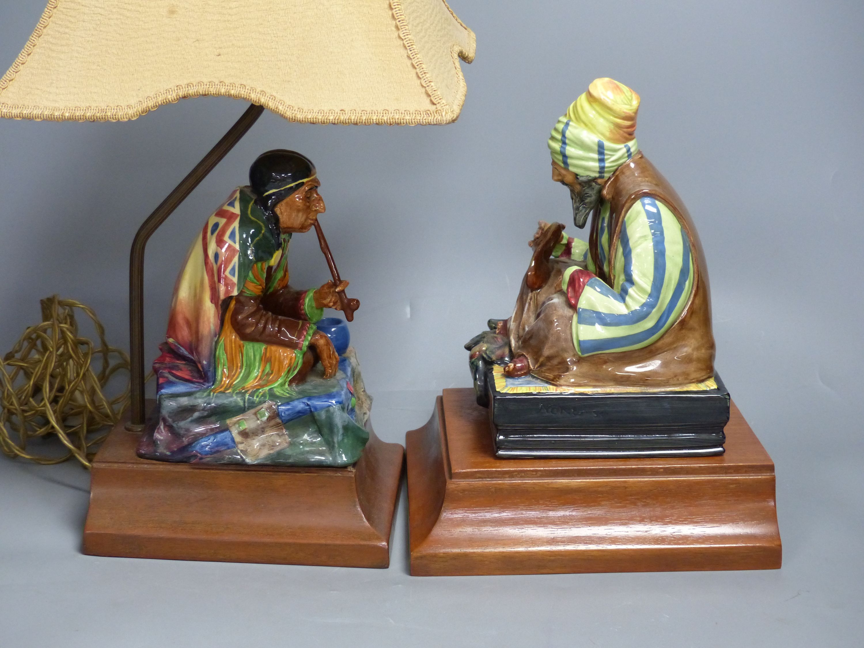 A Charles Noke for Royal Doulton, 'Cobbler', on wooden plinth and a similar figure of 'Calumet' (2)